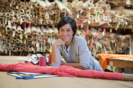 Bild Lächelnde Frau mit Stoffballen im Hintergrund